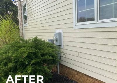 Home exterior after power washing, showing clean beige siding, a window, electrical meter, and neatly trimmed shrubs, with “After Power Washing” text and Central Power Wash logo.
